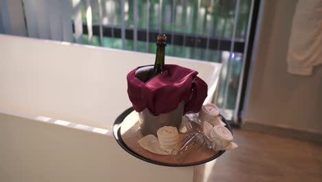 botella de champán en cubo con tela roja, interior para celebración, que simboliza el lujo y la festividad, toma estática con espacio de copia