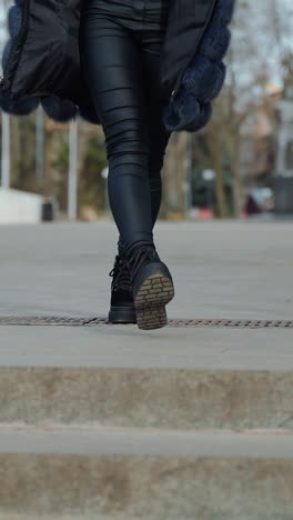 woman in black boots jumping on stairs