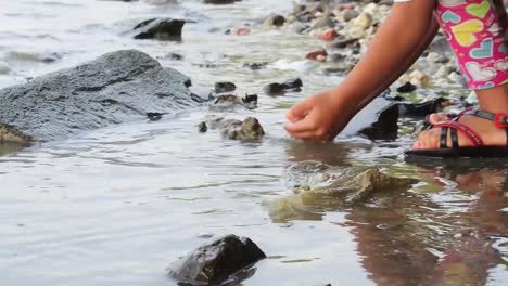 little girl washing hands on the beach