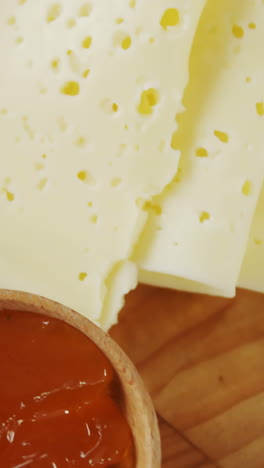 different types of cheese, tomatoes and bowl of jam and spices