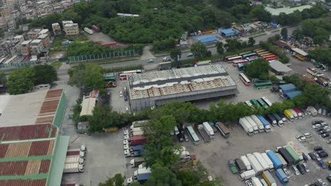 industrial building with vehicles parked around in countryside during the day