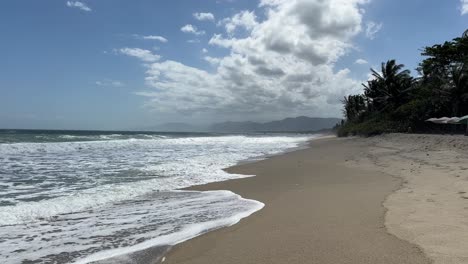 una escena de playa serena con olas espumosas que chocan suavemente contra las costas arenosas