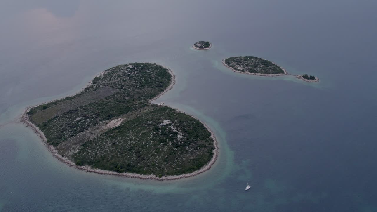 Isola dell'Amore illuminata dal tramonto a forma di cuore vista dall'alto, Croazia