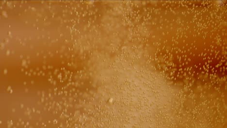 big bubbles in golden drink macro slowmotion