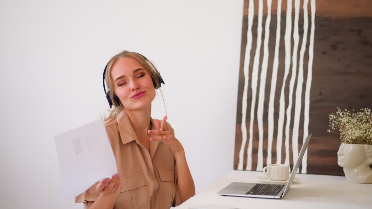 mujer con auriculares se mueve al ritmo arrojando papeles