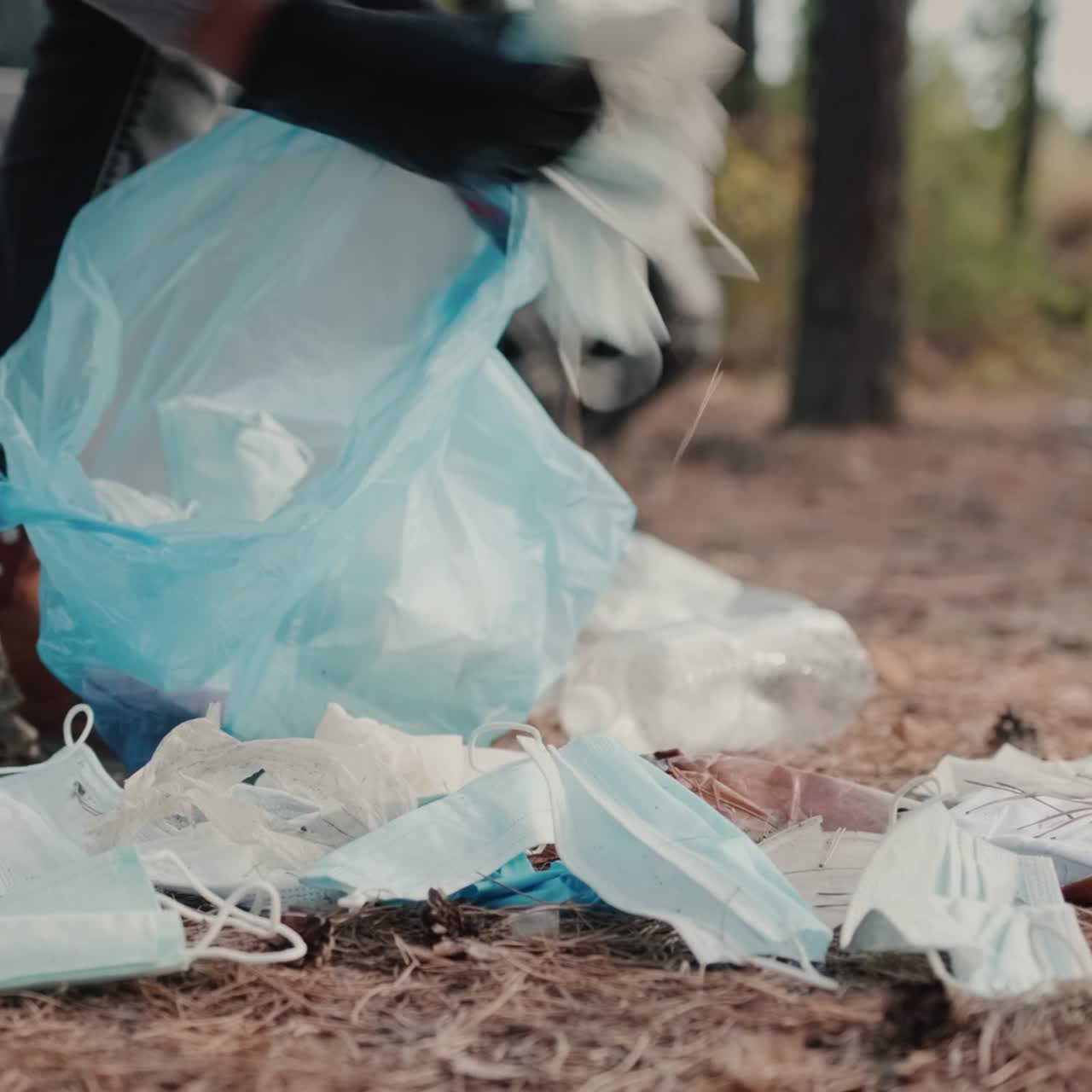 자원봉사자가 숲에서 쓰레기를 줍다