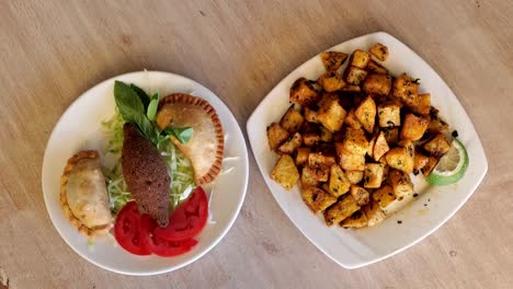 vista superior de los platos tradicionales árabes, kebbe, pasteles, tomate y plato de patatas picantes