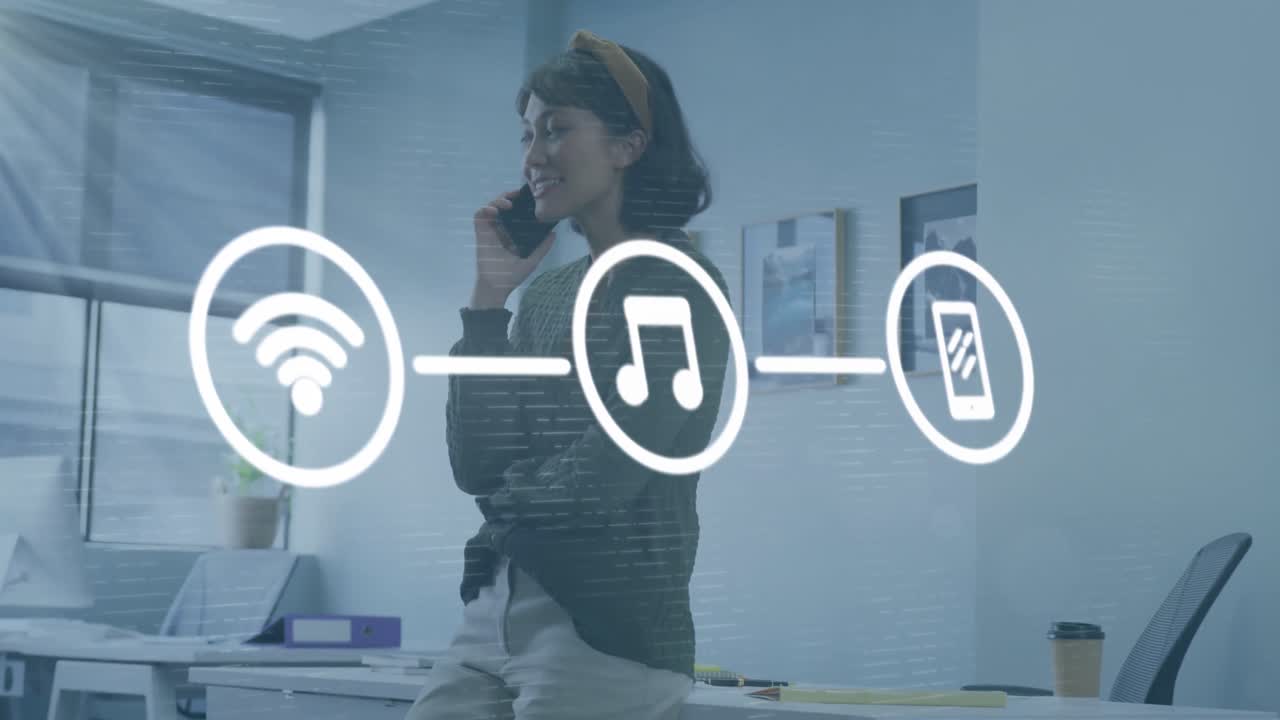 animación de una red de iconos digitales contra una mujer asiática hablando con un teléfono inteligente en la oficina