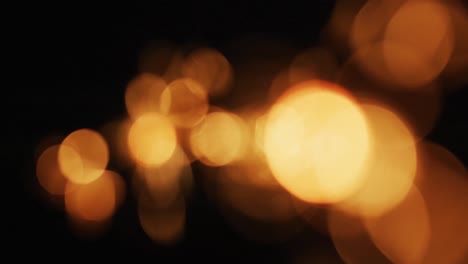 múltiples luces naranjas cálidas parpadeando sobre un fondo negro