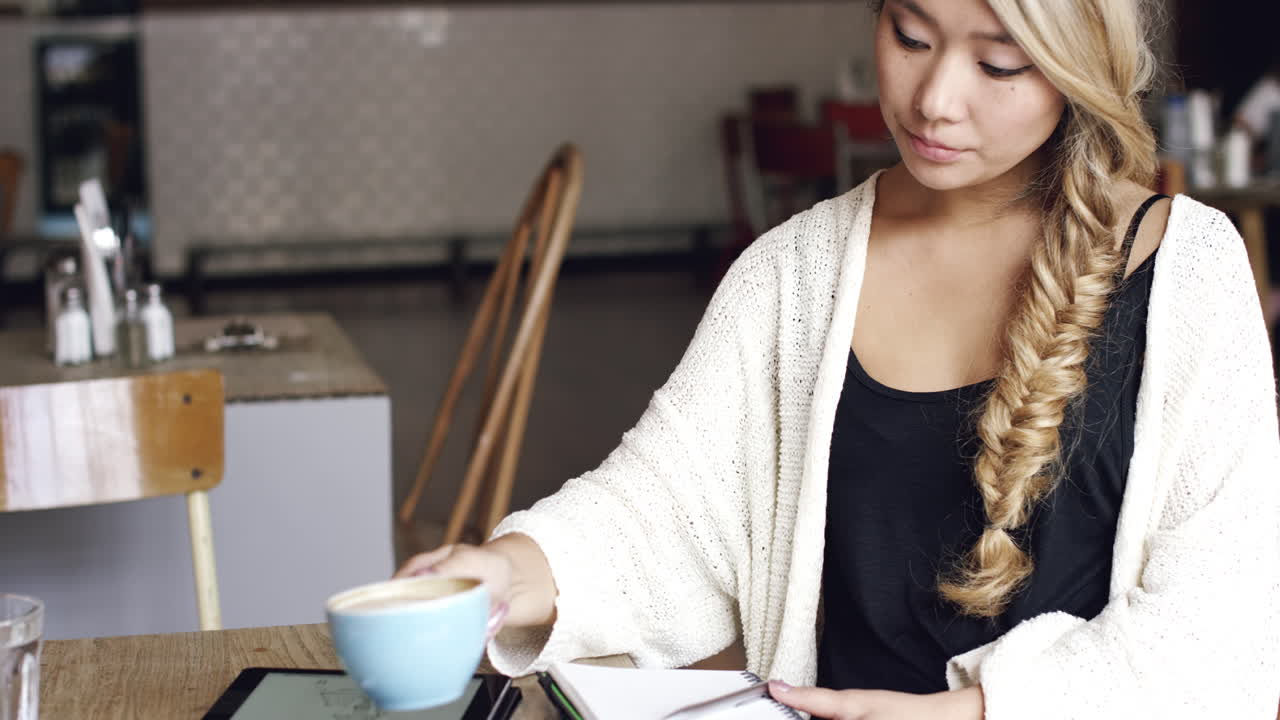mujer arquitecta trabajando en una cafetería bebiendo café