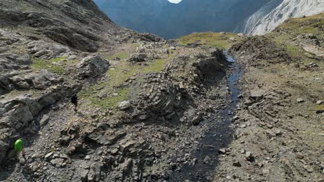 Luftaufnahmen-Von-Zwei-Rucksacktouristen,-Die-Durch-Eine-Felsige-Berglandschaft-Wandern
