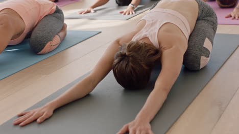Yoga-Klassengruppe-Gemischtrassiger-Frauen,-Die-Kinderpose-Praktizieren-Und-Einen-Gesunden-Lebensstil-Genießen-Und-Bei-Sonnenaufgang-Im-Fitnessstudio-Trainieren