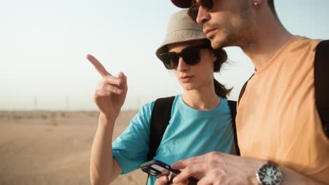 Paar-Benutzt-Smartphone-In-Der-Wüste