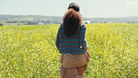 Vista-Trasera,-Flores-Y-Mujer-Corriendo-En-Un-Campo