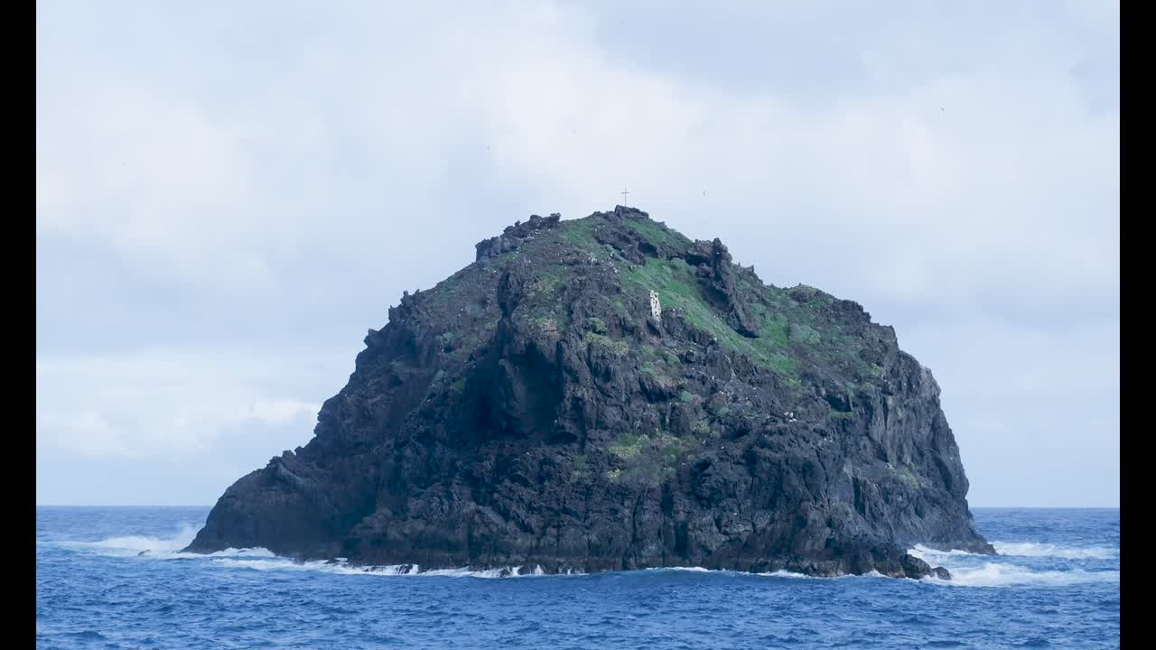 Piccola isola rocciosa con vegetazione verde nell'oceano