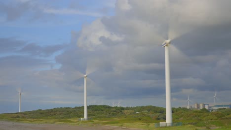 Windmills-spinning-and-storm-clouds-racing-by-with-pools-of-light-moving-across-landscape