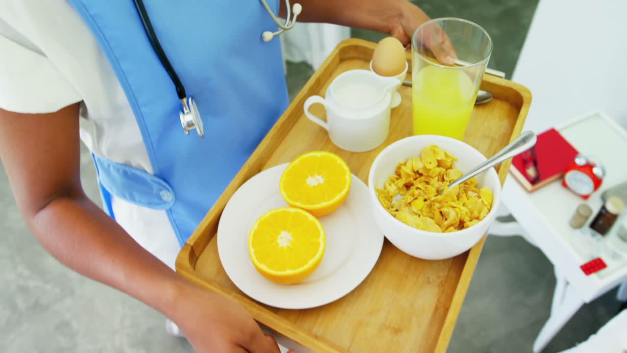 4k 침대에 있는 고령 여성에게 아침 식사를 제공하는 여성 의사