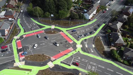 Aerial-view-vehicles-travelling-St-Helens-CYCLOPS-traffic-optimisation-junction-crossroad-intersection,-Tilt-down-flyover