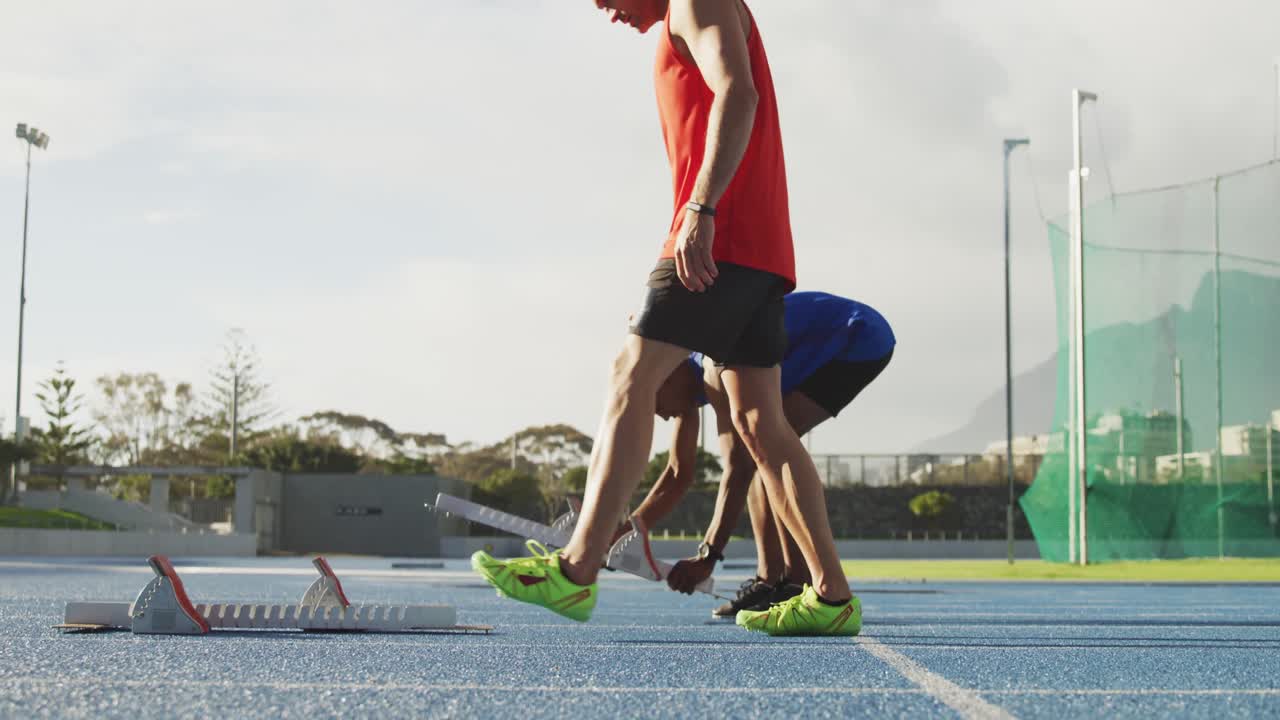 dos atletas preparándose para una carrera en el estadio