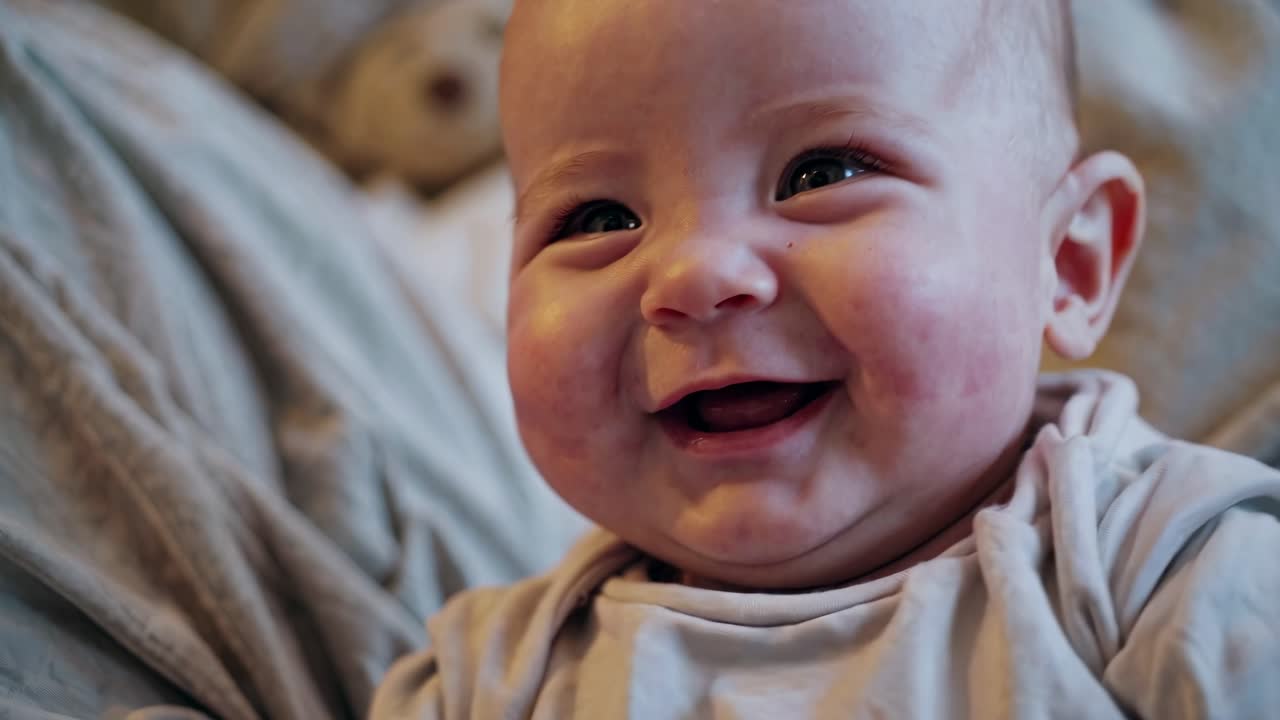 Close-up video of a joyful baby smiling, capturing innocence and happiness