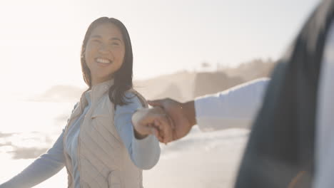 couple, holding hands and walking on a beach