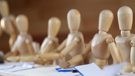 Wooden-figurines-having-meeting-in-conference-room