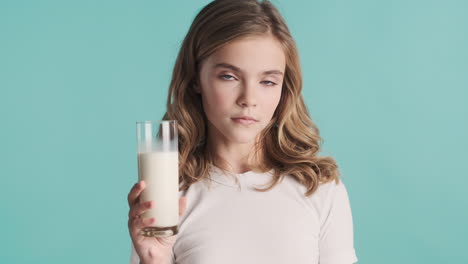 teenage caucasian girl in pijamas holding a glass of milk.