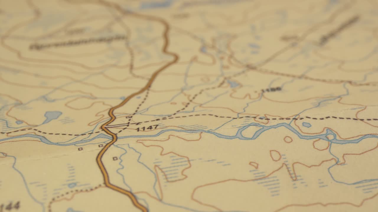 Macro shot of printed map following a water course, contours, shallow DOF