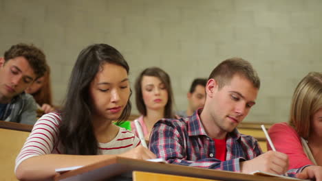 students listening carefully in lecture hall and taking notes