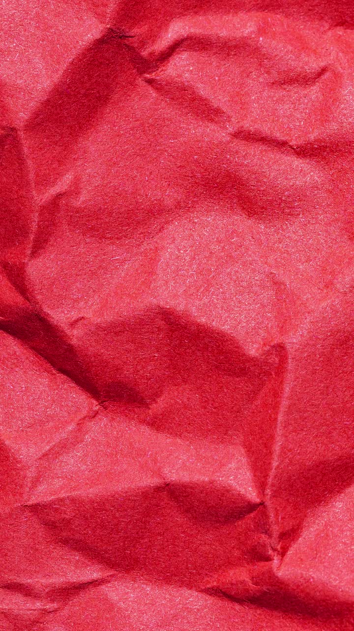 Vertical stop motion loop of crumpled red paper for animated backgrounds and creative projects