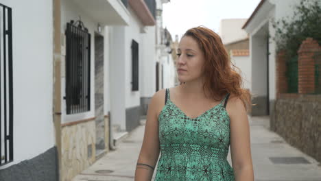 a woman in a dress walking down a street