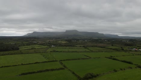 toma de drones de campos verdes con una cordillera en el fondo