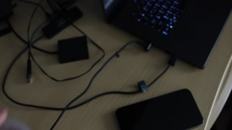 man at a table of electronics getting charged up with a caffeinated lemonade beverage with a desk full of electronic eqipment