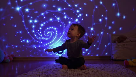 toddler mesmerized by glowing blue light projection
