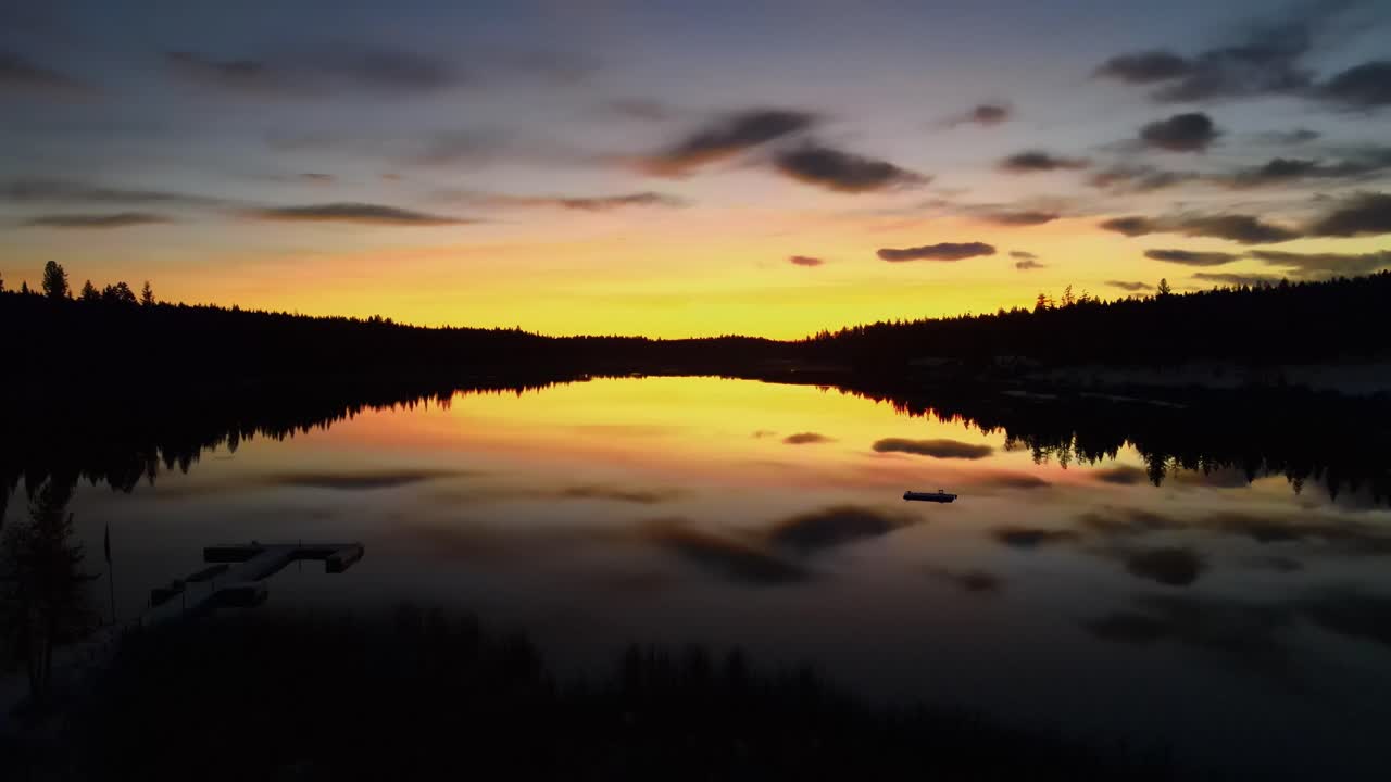 Glimpse Lake at colorful dramatic sunset from dock, aerial drone shot