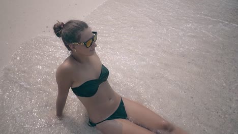 Wasser-Bedeckt-Junge-Frau-Mit-Haarbündel,-Die-Am-Strand-Liegt