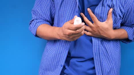 man experiencing chest pain and taking medicine