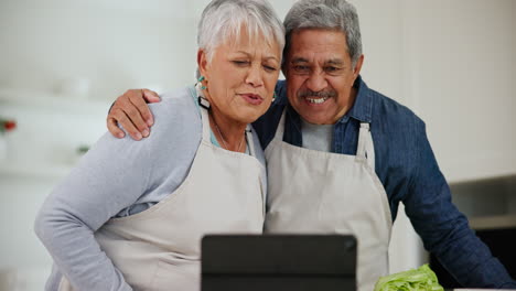 Kitchen,-wave-and-senior-couple-with-a-tablet