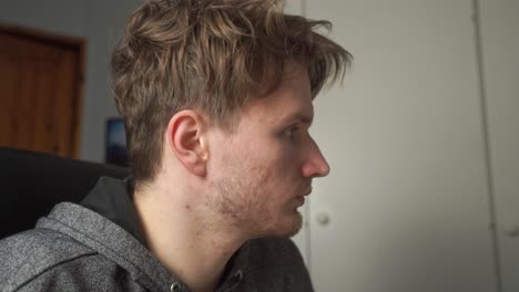 a young man focuses on the computer screen in front of him and wonders, why the work emails have indicated layoffs will start next week at his company