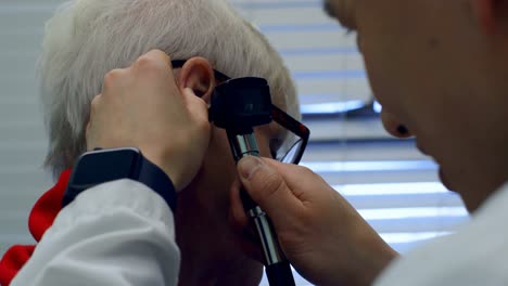 young asian male doctor examining a senior patient with otoscope in the clinic 4k