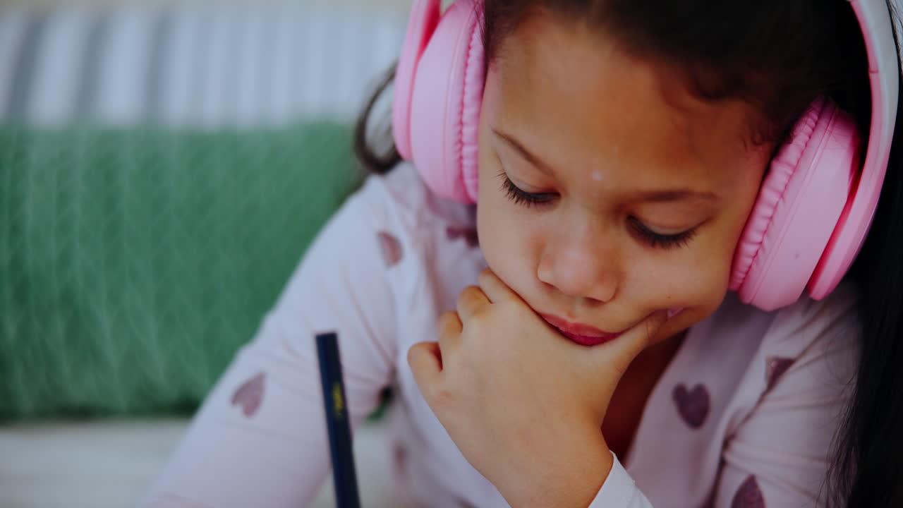 헤드폰으로 숙제를 하는 소녀