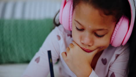 girl doing homework with headphones