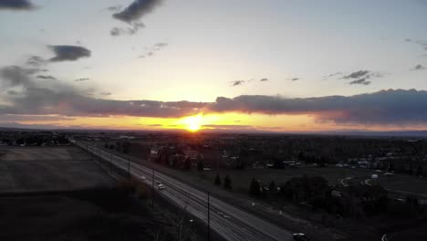 drone shot of sunset over the highway near a small town