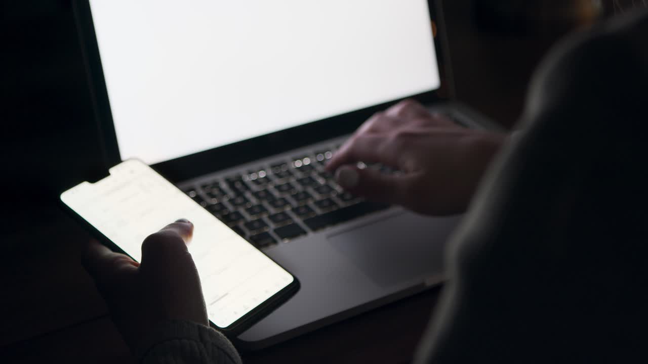 Person Working on Laptop and Smartphone at Night