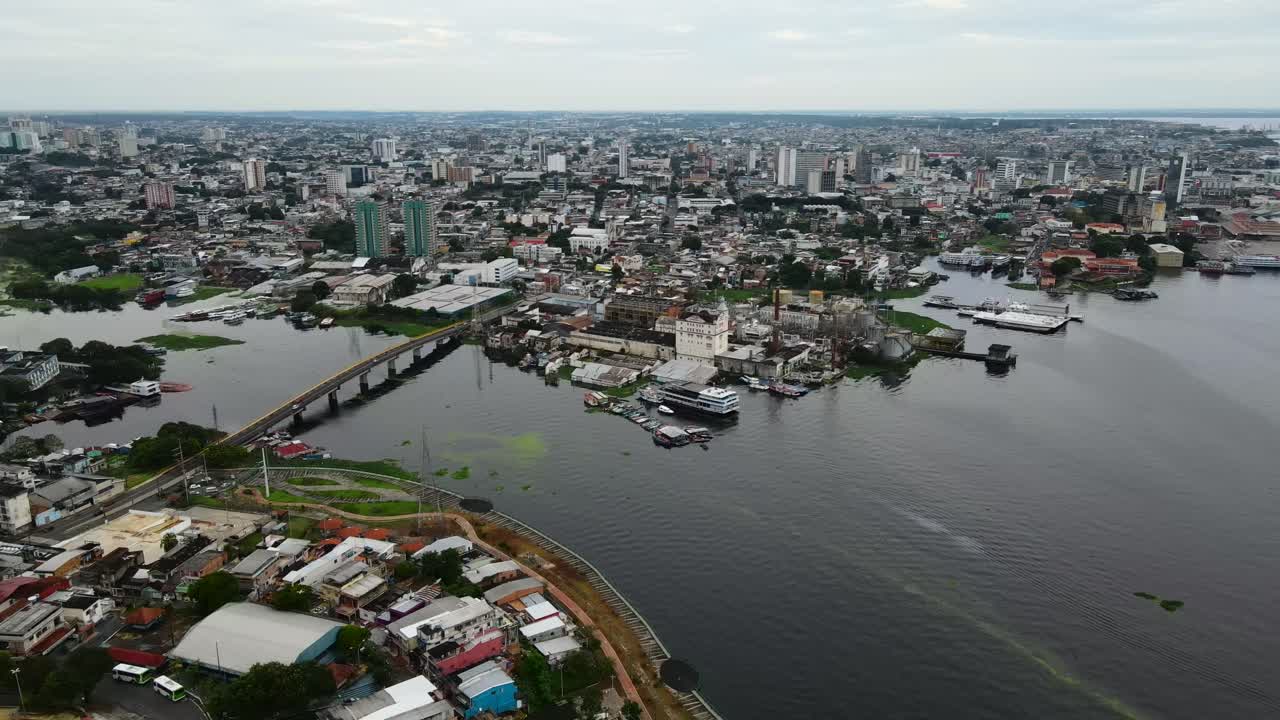 Città di Manaus e Rio Negro, che mostra un ponte e alghe nell'acqua sotto cieli nuvolosi, Brasile. Allontanamento aereo in ascesa. Registrato in 4K Apple ProRes 422.