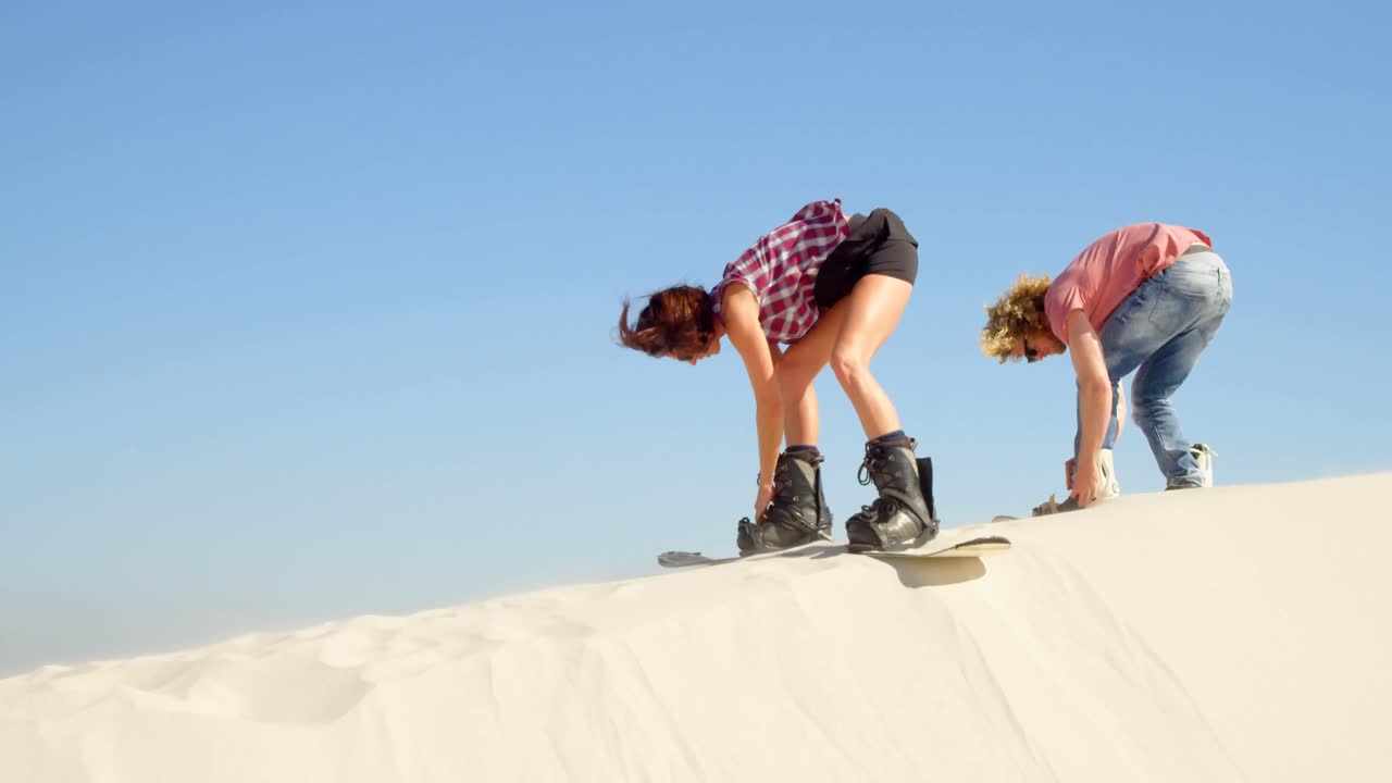 Coppia che fissa i sandboard agli scarponi 4k
