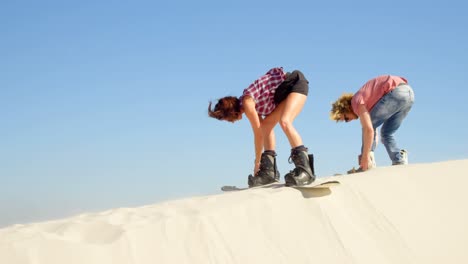 Couple-attaching-the-sand-boards-to-the-boots-4k