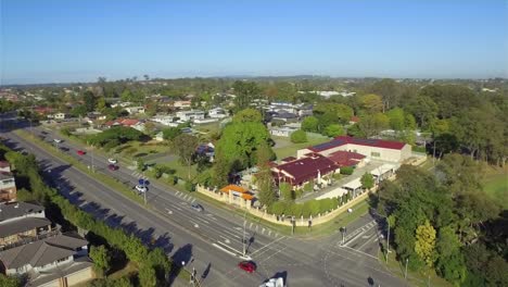 beautiful aerial drone shot with a smooth, wide orbit of a vietnamese temple in suburban brisbane, as the drone pulls back to reveal a busy intersection