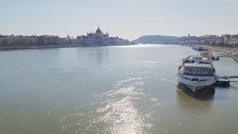 ferry boat moored in the danube river. hungarian parliament in the background. view from the margaret bridge. hungary