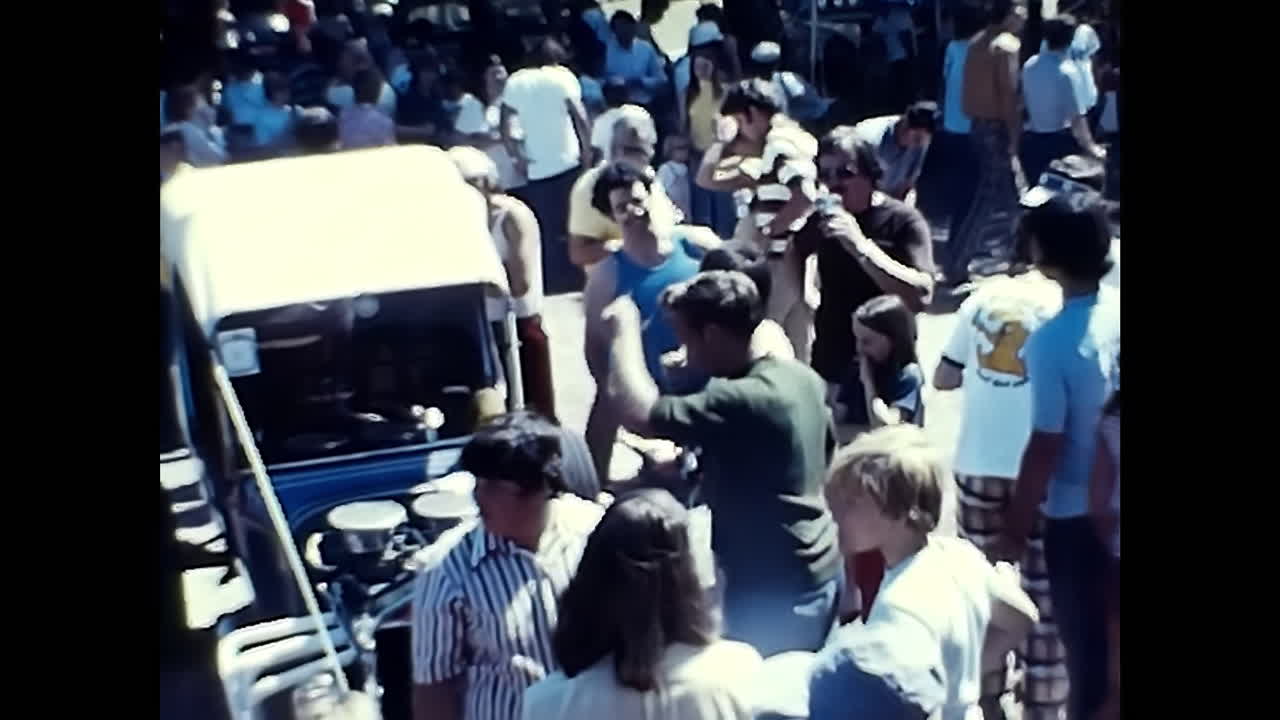 1970s USA Old Car Show, A Crowd of People Gathered Around a Truck. CIRCA USA - 1970s: A photograph captured at an old car show in the 1970s in the USA, displaying a crowd of people standing around a truck.